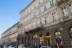 布达佩斯布达佩斯中心公寓的一座大型建筑,前面有汽车停放