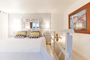 里昂美美里昂酒店的白色卧室配有白色的床和枕头