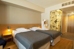 劳卡普轮卡Spa酒店的一间酒店客房,配有两张床和一件浴袍