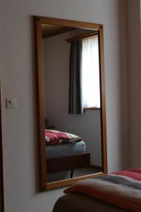 克洛斯特斯Hus Pravis的卧室内的镜子,卧室配有床和窗户