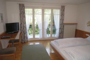 博登湖畔克雷斯波洛欢乐景旅馆的一间卧室配有一张床、一张书桌和一个窗户。