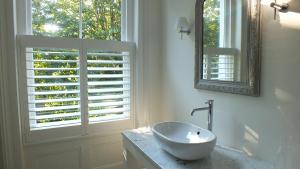 迪尔Bear's Well Bed & Breakfast的白色的浴室设有水槽和窗户。