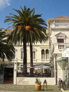 斯波托尔诺皇家别墅酒店的白色建筑前的棕榈树