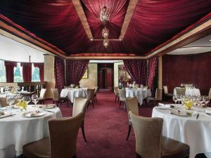 香港香港朗廷酒店的一间用餐室,配有白色的桌椅和红地毯