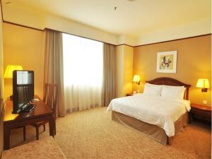 新山GBW酒店的酒店客房,配有床和电视