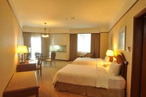 新山GBW酒店的酒店客房带两张床和一张桌子以及椅子。