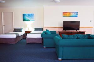 麦凯怀特蕾丝汽车旅馆的一间配备有沙发及电视的酒店客房