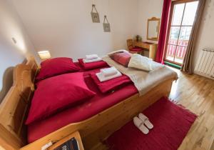 霍茨科波霍尔耶Apartments Mariborsko Pohorje的一间卧室配有一张大木床和红色床单