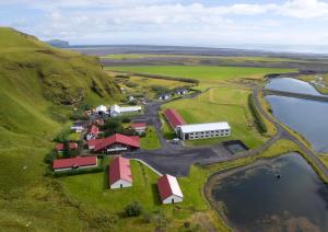 维克Hotel Katla by Keahotels的水边小山上农场的空中景观