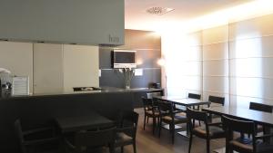 米兰科拉罗酒店的一间带桌椅和柜台的餐厅