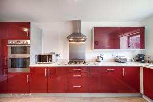 托基BEACHES - South Sands beach house的一间带红色橱柜和炉灶的厨房