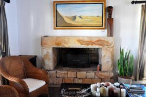 埃兰兹湾Draaihoek Lodge & Restaurant的客厅设有壁炉,墙上挂有绘画作品