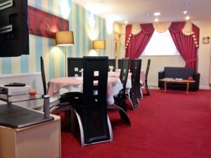 伦敦罗马路市场市景酒店的一间铺有红地毯并配有桌椅的用餐室