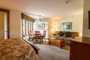 温德姆Winwood Inn & Condominiums的客厅配有床、沙发和桌子