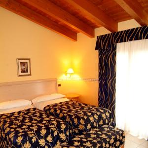PegognagaHotel Ristorante Novecento的酒店客房设有床和窗户。
