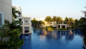 七岩Hua Hin Blue Lagoon的享有拥有建筑和棕榈树的游泳池的景色