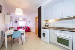 阿利坎特Alicante Apartments的厨房以及带桌子和洗衣机的客厅。