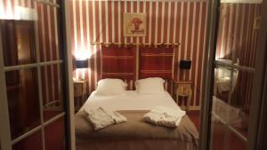 Germigny-lʼEvêqueLOGIS - Hôtel & Restaurant Le Gonfalon的一间卧室配有一张床,上面有两条毛巾