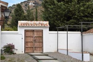 埃尔乔罗Cortijo Don Rodrigo的一座白色的小建筑,设有木门