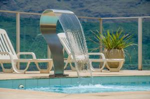 欧鲁布兰科塞拉皇宫酒店 的游泳池中的喷泉,带椅子