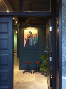 DahanMIAOKO青年旅館的走廊上设有两张凳子,墙上挂着一幅画