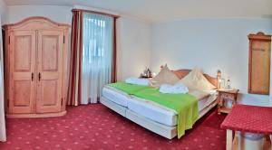 雷宁根Hotel Zur Eisenbahn的一间卧室配有一张带绿毯的床
