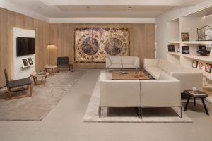 塞维利亚布雷罗斯美利亚酒店的客厅配有白色的沙发和桌子
