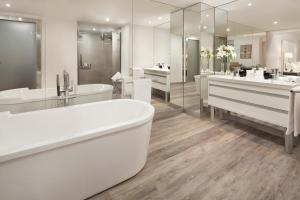 塞维利亚布雷罗斯美利亚酒店的白色的浴室设有2个盥洗盆和1个浴缸。