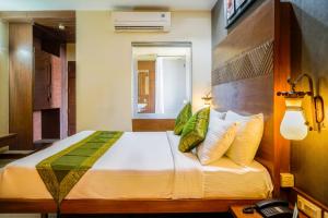 奥兰加巴德Hotel Sonia CIDCO的一间卧室配有一张大床,提供黄色和绿色的枕头
