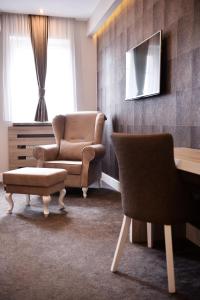 巴尼亚卢卡伊德亚酒店的客厅配有两把椅子、一把椅子和一张沙发