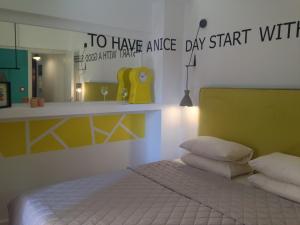 塞萨洛尼基The Orange Apartments的一间卧室配有一张带黄色床头板和镜子的床