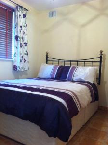 罗斯莱尔Glendale Chestnut Grove的一间卧室配有一张带蓝色床单的床和一扇窗户。