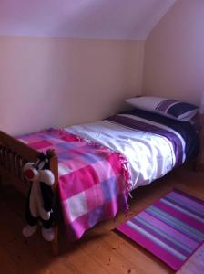 罗斯莱尔Glendale Chestnut Grove的一间卧室配有一张带粉红色和紫色毯子的床