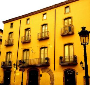 曼雷沙卡萨奥乐尔公寓的带阳台的黄色建筑和街灯