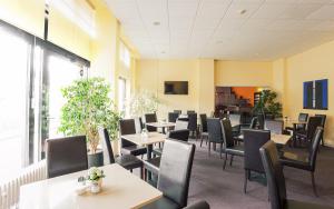 柏林希迪斯酒店的用餐室设有桌椅和窗户。
