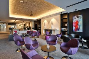 博宾根申普酒店的一间设有紫色椅子和桌子的等候室