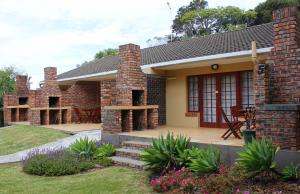 伊丽莎白港African Aquila Guest Lodge的砖屋,设有庭院和桌子