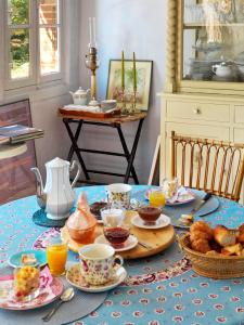 图卢兹里亚别墅住宿加早餐旅馆的一张桌子,上面有蓝色的桌布,上面有早餐食品