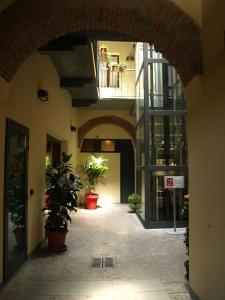 蒙扎卡罗尔酒店 的建筑里空荡荡的走廊,有盆栽植物