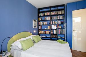 热那亚Sull'Acqua del Porto Antico的一间蓝色卧室,配有床和书架