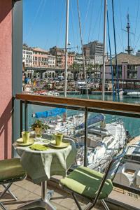 热那亚Sull'Acqua del Porto Antico的一个带码头的阳台,配有桌椅