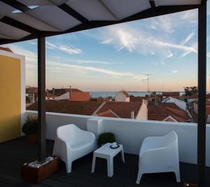 塞图巴尔Day Off Suite&Hostel的阳台配有两把椅子,享有海景。