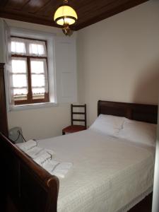 索茹Casa de RioBom的一间卧室配有一张带白色床单的床和一扇窗户。