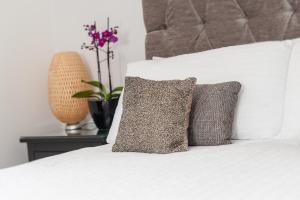 爱丁堡吉尔莫入口公寓的一张带两个枕头的白色床和一张桌子上的植物