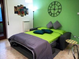 奥里亚Casa Oria Friendly的卧室配有一张挂在墙上的带时钟的床