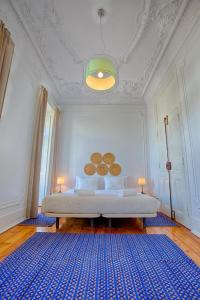 里斯本达维拉旅馆的一间卧室配有一张大床和蓝色地毯。
