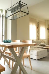 帕诺尔莫斯雷斯蒙Philoxenia Villas的用餐室配有带椅子的木桌和灯具