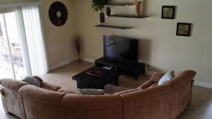 珊瑚角Sunny Paradise的客厅配有棕色沙发和电视