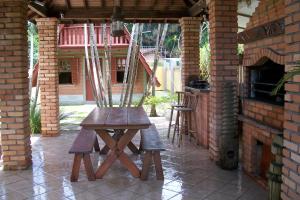 弗洛里亚诺波利斯Pousada Farol da Barra的户外庭院里的一张木桌和椅子