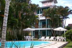 弗洛里亚诺波利斯Pousada Farol da Barra的酒店设有带椅子和遮阳伞的游泳池